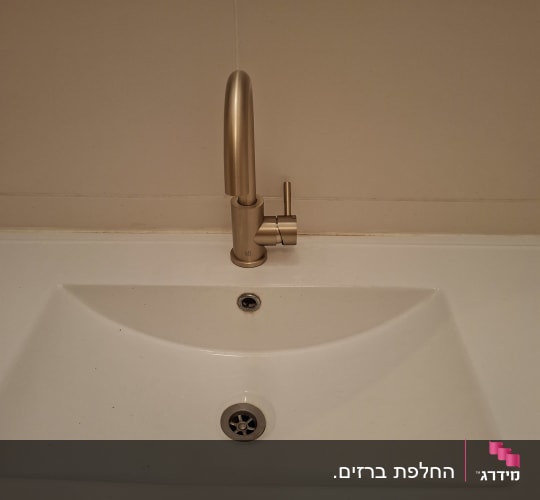 כיור עם ברז זהב מותקן על קיר